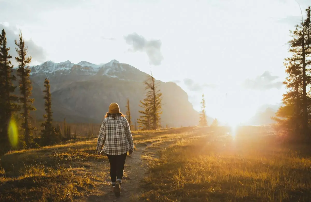 La libertad que se dona: compromiso y decisión Persona frente a un horizonte luminoso al inicio de un camino, simbolizando la libertad que se convierte en compromiso y proyecto de vida